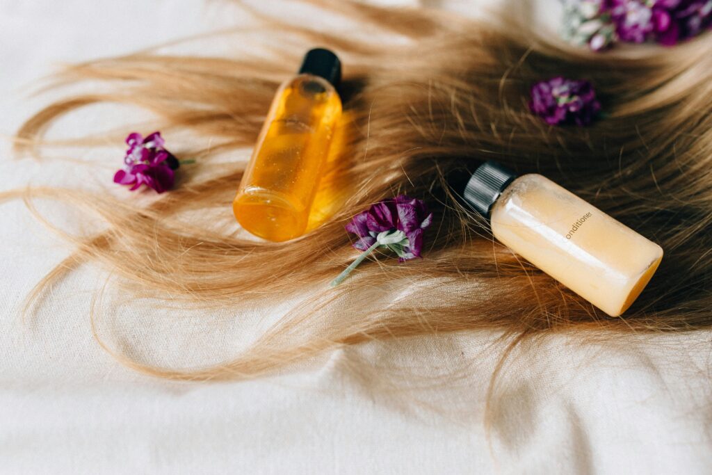 Na imagem mostra um cabelo loiro com alguns produtos de cuidados capilares sobre ele, onde expressa o tema "qual faz mais diferença nos cabelos"?