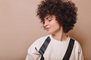 Mulher de cabelo cacheado curto, onde representa o tema: Melhores Produtos para cabelos cacheados 2025
