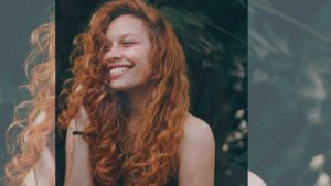 Mulher ruiva com um cabelo cacheado, solto com volume, onde representa o tema: LAVITAN CABELOS E UNHAS FUNCIONA MESMO? Descubra a Verdade que Ninguém Te Conta!