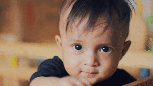 Mostra um bebê com cabelo grande com um pouco de falha 